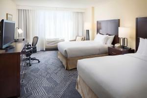 科默斯洛杉机希尔顿逸林酒店的酒店客房设有两张床和电视。