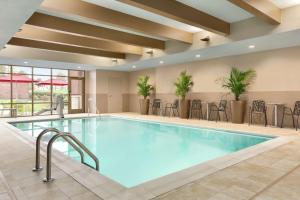 弗洛伦斯Home2 Suites By Hilton Florence Cincinnati Airport South的游泳池位于酒店带桌椅的客房内