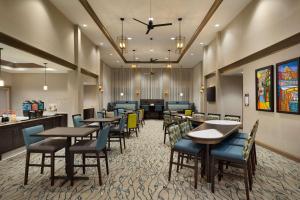 南海文Homewood Suites By Hilton Southaven的一间带桌椅的餐厅和一间酒吧