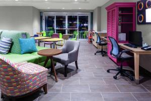奥兰多Home2 Suites By Hilton Orlando South Park的一间设有桌椅和沙发的等候室