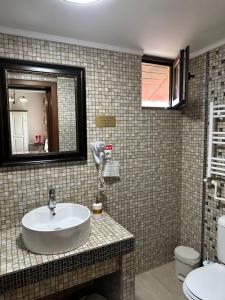 普洛耶什蒂Home Simoni的一间带水槽、镜子和卫生间的浴室