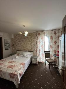 普洛耶什蒂Home Simoni的卧室配有床、椅子和窗户。