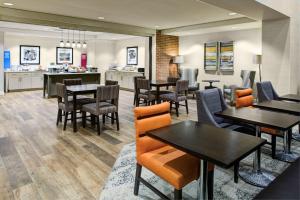 匹兹堡Hampton Inn & Suites Pittsburg Kansas Crossing的一间带桌椅的餐厅和一间厨房