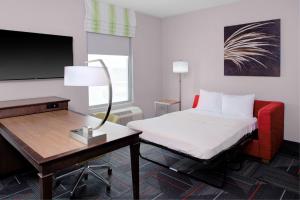 哥伦布Hampton Inn & Suites Columbus Scioto Downs的酒店客房配有一张床、一张书桌和一台电视。