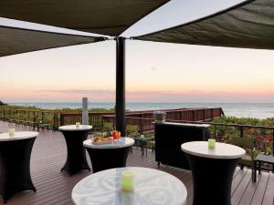 墨尔本墨尔本海滨希尔顿逸林套房酒店的一个带桌椅的海景庭院