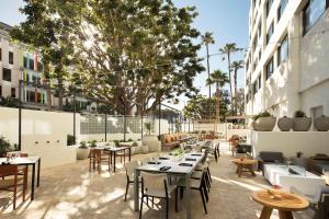 洛杉矶Hilton Santa Monica的庭院内的餐厅,配有桌椅