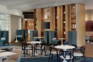 提内克蒂内克/格兰普恩特汉普顿酒店的一间带桌椅和电视的餐厅