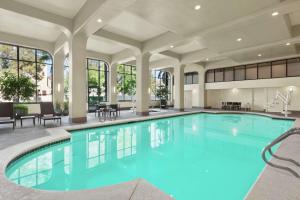 阿卡迪亚Embassy Suites by Hilton Arcadia-Pasadena Area的大楼内的一个蓝色海水游泳池