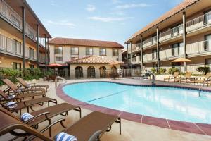 隆波克Embassy Suites by Hilton Lompoc Central Coast的一座带椅子的酒店游泳池以及一座建筑