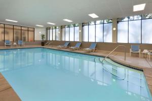圣路易斯-奥比斯保圣路易斯奥比斯保希尔顿合博套房酒店的大楼内带椅子的大型游泳池