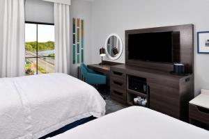 锡达福尔斯Hampton Inn Cedar Falls Downtown, Ia的酒店客房设有两张床和一台平面电视。