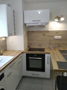 勒卡内代莫尔Appartement T2, 4 personnes, disponible jusqu au Samedi 2 sept 2023的厨房配有白色橱柜和炉灶烤箱。