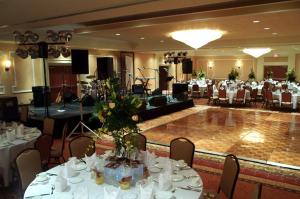 安德森安德森希尔顿花园酒店的宴会厅配有白色的桌椅和舞台