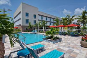 那不勒斯Home2 Suites By Hilton Naples I-75 Pine Ridge Road的游泳池,带椅子和遮阳伞