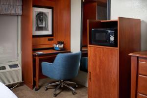 安娜堡安阿伯市南区汉普顿酒店的客房设有书桌、椅子和电视。