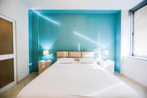 地拉那ApartHotel Toptani Center View的一间卧室设有一张蓝色墙壁的大床