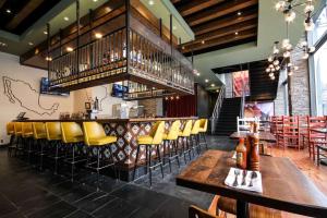 亚特兰大亚特兰大市区希尔顿花园旅馆的餐厅设有配备黄色椅子的酒吧