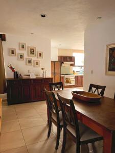 瓜纳华托LAS ALAMEDAS Departamentos céntricos con estacionamiento privado的厨房以及带木桌和椅子的用餐室。