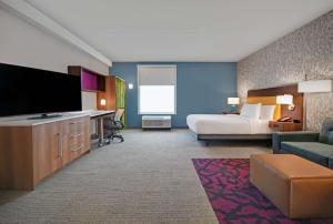 亚特兰大Home2 Suites by Hilton Atlanta Airport North的配有一张床和一台平面电视的酒店客房
