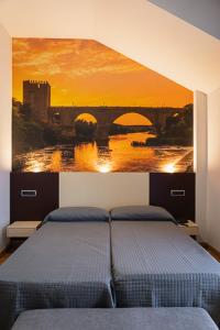 PulgarHotel-Asador Montes Oretanos的一间卧室,配有一张带桥梁画的床铺