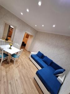 第比利斯Mery's Family Apartment的客厅配有蓝色的沙发和桌子