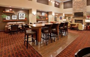 沃特敦沃特敦希尔顿恒庭旅馆&套房酒店的餐厅设有酒吧,配有桌椅