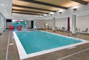 ArdenHome2 Suites By Hilton Asheville Airport的游泳池位于酒店客房内,配有椅子和桌子