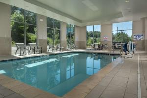 阿什维尔北卡罗来纳州阿什维尔比尔特摩村希尔顿欢朋酒店的大楼内一个带桌椅的游泳池