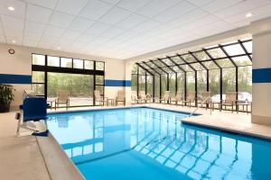 温莎洛克斯布拉德利国际机场希尔顿逸林酒店的大楼内的一个蓝色海水游泳池