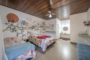 沙帕达-杜斯吉马朗伊斯Pousada Luz do Jamacá的一间卧室设有两张床,墙上挂着花壁画