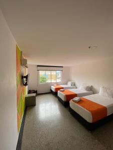 布卡拉曼加HOTEL RIVERA CENTRAL的带三张床和窗户的客房