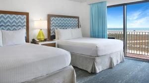 圣徒皮特海滩比尔马海滩度假酒店的带阳台的酒店客房内的两张床