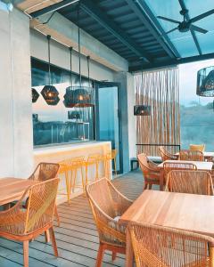 曼塔Eolia Sustainable Design Hotel的一间在甲板上配有木桌和椅子的餐厅