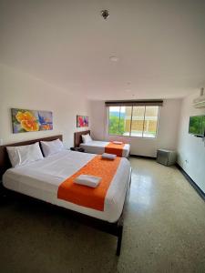布卡拉曼加HOTEL RIVERA CENTRAL的一间设有两张床和窗户的大卧室