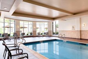 波士顿波士顿洛根机场希尔顿花园酒店的一座配有桌椅的酒店游泳池