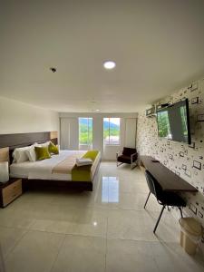 布卡拉曼加HOTEL RIVERA CENTRAL的一间大卧室,配有一张大床和一台电视