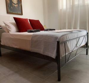 雅典Central Apartment near metro Keramikos- Airport的卧室内的一张带红色和白色枕头的床
