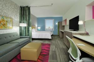 亚瑟港Home2 Suites By Hilton Port Arthur的酒店客房设有一张沙发和一张床