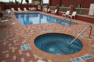 布朗斯维尔布朗斯维尔汉普顿套房旅馆的周围设有大型游泳池,游泳池周围设有椅子和椅子
