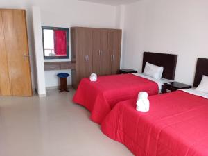 HuanchaquitoLa casa de Maria- Playa Huanchaquito的酒店客房,配有两张带红色床单的床