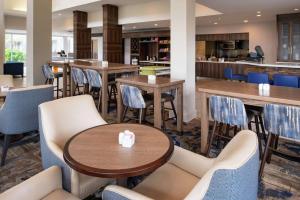巴吞鲁日巴顿鲁日机场希尔顿花园酒店的一间带桌椅的餐厅和一间酒吧