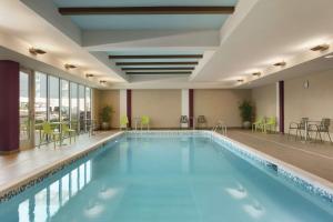 威廉斯维尔Home2 Suites By Hilton Williamsville Buffalo Airport的游泳池位于酒店客房内,配有桌椅