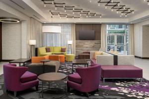 哥伦比亚Hilton Garden Inn Columbia Airport, SC的酒店大堂设有五颜六色的桌椅