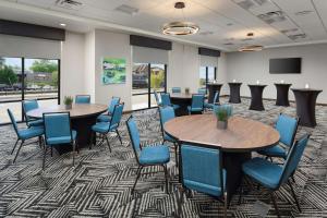 蓝岭Hampton Inn Blue Ridge, GA的一间会议室,配有两张桌子和蓝色椅子