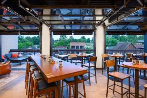 蓝岭Hampton Inn Blue Ridge, GA的餐厅设有桌椅和大窗户。