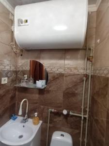 图库姆斯Dzīvoklis Tukuma centrā的浴室配有白色卫生间和盥洗盆。