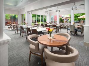 查塔努加查塔努加市中心希尔顿花园酒店的餐厅设有桌椅和窗户。