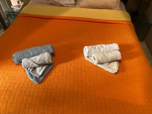 雅典SoHoAthine Apartment的床上的两条毛巾和橙色床单