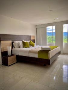 布卡拉曼加HOTEL RIVERA CENTRAL的一间卧室设有一张大床和大窗户