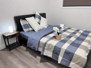 卡尔加里Private Entire Townhouse Retreat Close to Lake的一张带蓝色和白色毯子的床和一张带鲜花的桌子